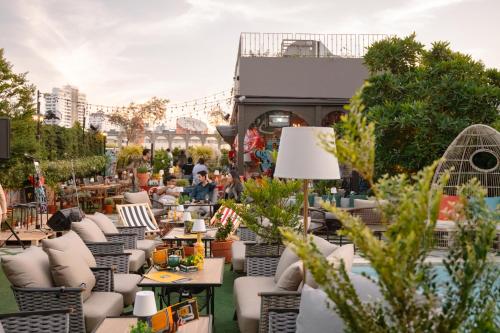 een terras met tafels en stoelen en mensen op de achtergrond bij The Quartier Hotel Phromphong - Thonglor in Bangkok