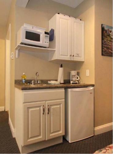 a kitchen with a sink and a microwave at Studio East Motel in Ogunquit