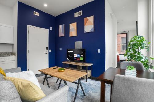 a living room with a blue wall and a tv at CozySuites at William in Pittsburgh