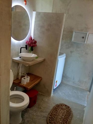 a bathroom with a sink and a toilet and a mirror at Casa Bella Guriú in Guriú