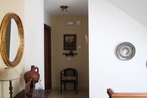 a room with a mirror and a chair and a table at Easy Nerja Bronce in Nerja