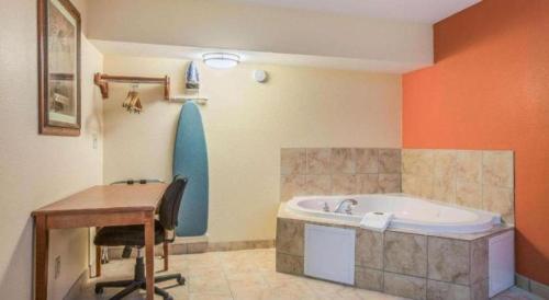 een badkamer met een bureau en een bad bij Rodeway Inn & Suites in Lakeview