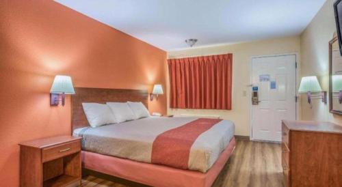 een hotelkamer met een bed en een rood raam bij Rodeway Inn & Suites in Lakeview