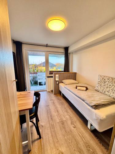 a bedroom with a bed and a desk and a window at City Aarhus in Aarhus