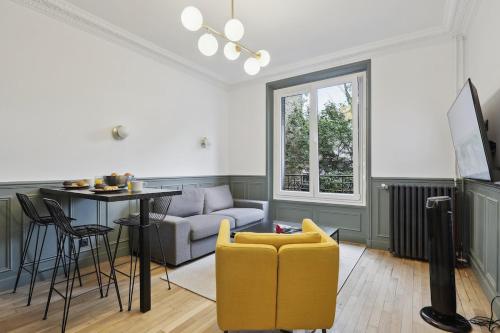 een woonkamer met een bank en een tafel bij Maisons Alfort 1 Modern flat in Maisons-Alfort
