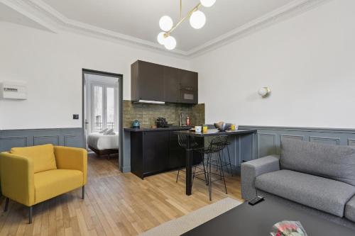 een woonkamer met een gele stoel en een keuken bij Maisons Alfort 1 Modern flat in Maisons-Alfort