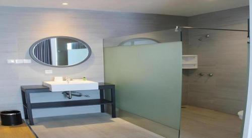 a bathroom with a sink and a mirror and a shower at Buana Lestari Hotel in Klandasan Kecil