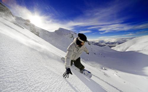 a man riding a snowboard down a snow covered slope at Appartement Gimpl in Fusch an der Glocknerstraße