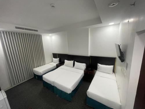 a hotel room with two beds and a tv at فندق أمل المشاعر in An Nikāshah