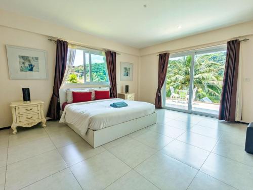 a bedroom with a bed and a large window at Blue Cove Pool Villa - by KohChangVillas in Trat