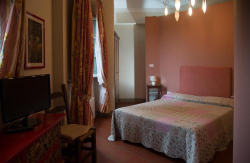 a bedroom with a bed and a flat screen tv at Golf Club Bellosguardo resort in Vinci