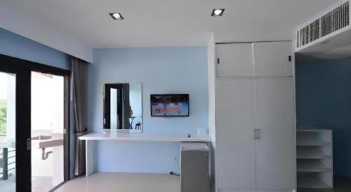 a white kitchen with a sink and a mirror at Sixty-Sixplace in Ban Khok Lo