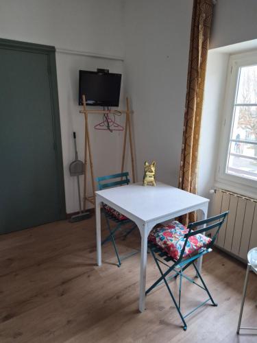 un tavolo bianco e due sedie in una stanza di Le studio de Fabio a Bollène