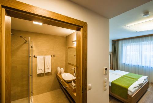 a bathroom with a bed and a sink and a shower at Gut Leithaberg in Jois