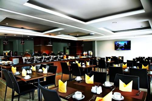 een eetkamer met tafels en stoelen in een restaurant bij Amantis Hotel in Demak