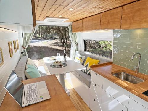 een camperkeuken met een laptop op een tafel bij Glamping converted van with bathroom in Los Cristianos