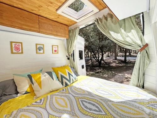 een slaapkamer met een bed en een raam bij Glamping converted van with bathroom in Los Cristianos