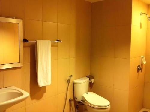 a bathroom with a toilet and a sink at Hotel Benua in Pulupanda