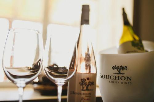 two wine glasses sitting next to a bottle of wine at Casa Bouchon Hotel Boutique in San Javier