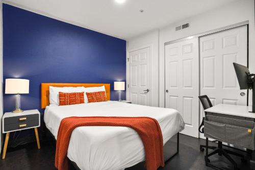 a bedroom with a large bed and a blue wall at CozySuites at William in Pittsburgh