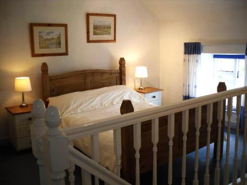 a bedroom with a bed and two lamps and a staircase at 1 Bed in Ampleforth oc-b34674 in Ampleforth