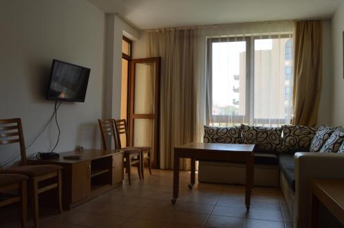 a living room filled with furniture and a tv at Arcadia Apart Complex in Sunny Beach