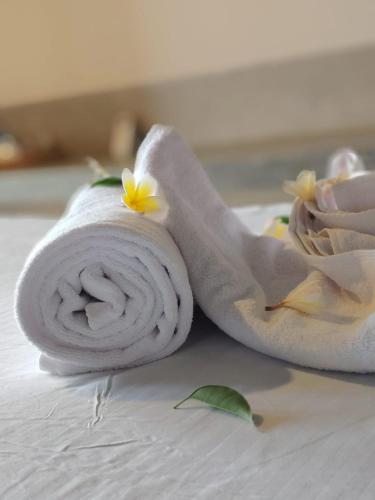 a rolled up towel with flowers on a bed at Trident Sea Hotel in Negombo