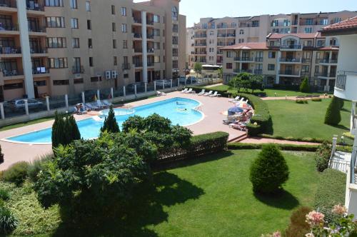 a park with a pool and lawn chairs at Arcadia Apart Complex in Sunny Beach
