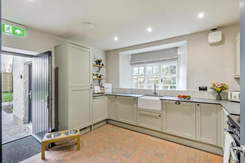 a kitchen with white cabinets and a sink and a window at 3 Bed in Neath oc-p34366 in Neath