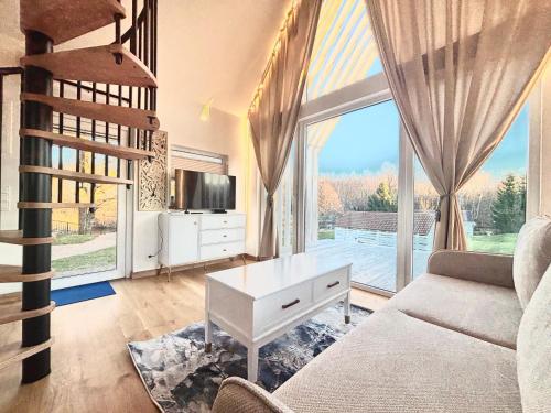 a living room with a couch and a large window at Namelis su sauna SMILGA in Radailiai
