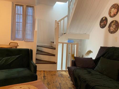 ein Wohnzimmer mit einer Couch und einer Treppe in der Unterkunft La source, maison de ville vieux Périgueux in Périgueux