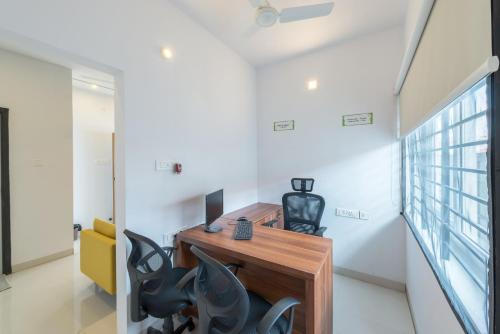 una oficina con escritorio y sillas en Itsy By Treebo - Corner stay, en Coimbatore