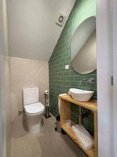 een badkamer met een toilet, een wastafel en een spiegel bij Quinta do Passal in Parada de Ester