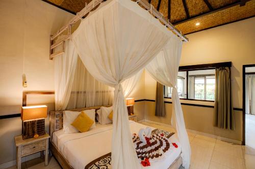 a bedroom with a bed with a canopy at Dupa Ubud in Ubud