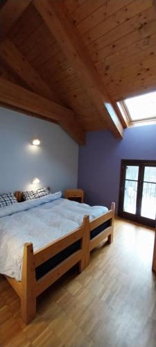 een slaapkamer met een groot bed in een kamer met houten plafonds bij Rifugio Alevé in Castello