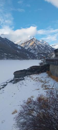 een grote hoeveelheid water met een besneeuwde berg bij Rifugio Alevé in Castello