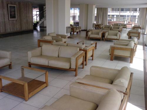 un vestíbulo con sofás y mesas en un edificio en Playa Club Apart en Miramar