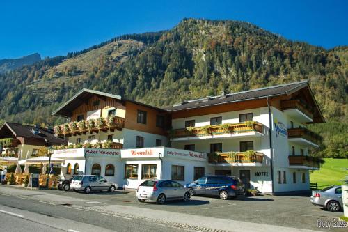 a large building with cars parked in a parking lot at Appartement Gimpl in Fusch an der Glocknerstraße