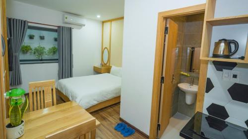 a small room with a bed and a bathroom at Minh Hung Apartment & Hotel in Danang