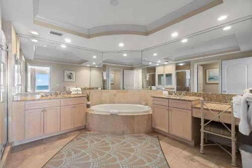a large bathroom with a tub and a large mirror at Indigo West 1404 in Perdido Key