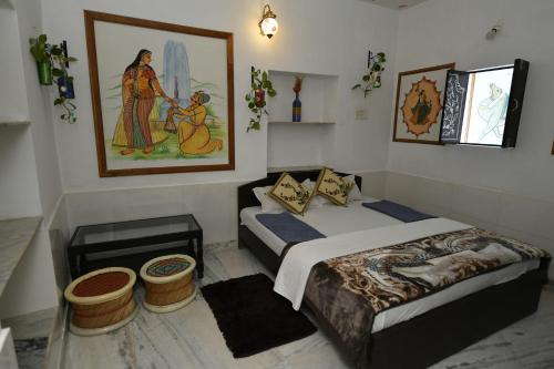 ein Schlafzimmer mit zwei Betten und einem Gemälde an der Wand in der Unterkunft L G Guest House in Jodhpur
