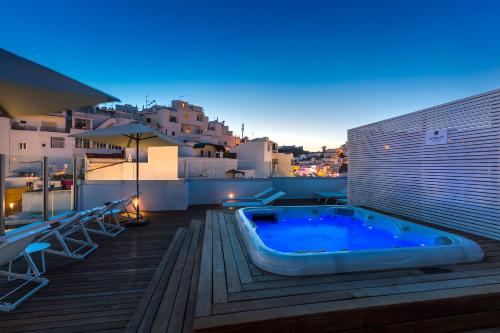 a hot tub sitting on top of a deck at Hotel Baltum in Albufeira