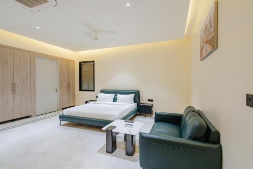 a bedroom with a bed and a couch and a table at CS Luxurio Presendential Suites Gachibowli in Hyderabad