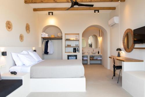 a bedroom with a white bed and a desk at Althea Anafi Suites in Anafi