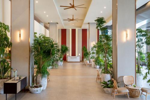 a hallway with potted plants in a lobby at Swiss-Grand Beach Resort Kuantan - Newly Upgraded 5-Star in Kuantan