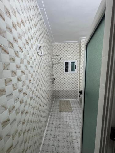 アビジャンにあるAKAWABA Residenceの白いタイルのシャワー付きのバスルーム