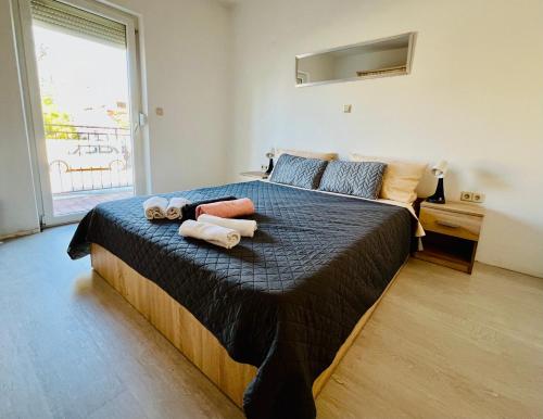 een slaapkamer met een groot bed met handdoeken erop bij Apartmani Cassiopeia in Murine