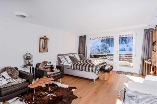 een woonkamer met een bed en een bank bij Titlis Studio Engelberg with Balcony great View in Engelberg