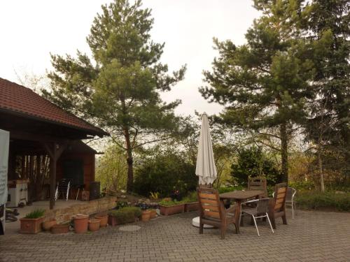 eine Terrasse mit einem Tisch, einem Sonnenschirm und Stühlen in der Unterkunft Hotel Glück in Ebersbach an der Fils