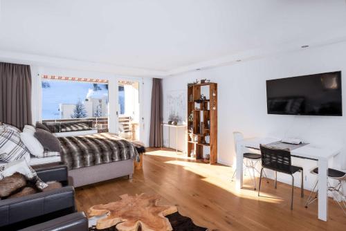 a living room with a bed and a table and a desk at Titlis Studio Engelberg with Balcony great View in Engelberg